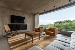 a living room with a couch and a tv at Casa Cave by Achei in Canela