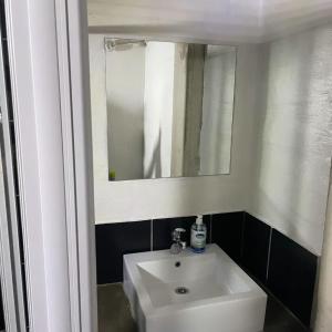 Un baño con un lavabo blanco y un espejo. en The Beverly by maboneng, en Johannesburgo