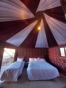 two beds in a room with a wall at Khazali Mountain Camp in Wadi Rum