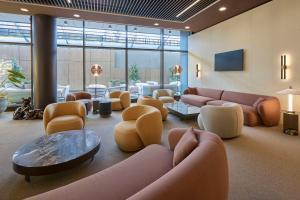 a lobby with couches and chairs and a table at Radisson Blu Hotel, Bergamo ChorusLife in Bergamo