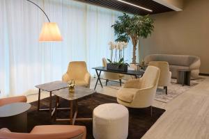 a waiting room with chairs and a table at Radisson Blu Hotel, Bergamo ChorusLife in Bergamo +131 photos