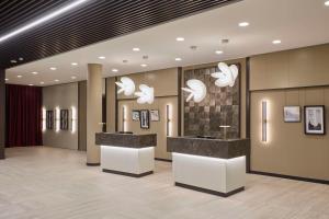 a lobby with a reception desk and chandeliers at Radisson Blu Hotel, Bergamo ChorusLife in Bergamo