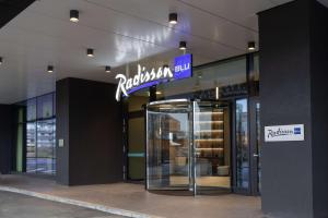 a store with a revolving door in front of a building at Radisson Blu Hotel, Bergamo ChorusLife in Bergamo