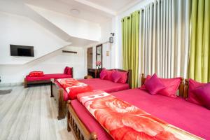 Habitación con 3 camas y sábanas rosas. en Villa Grand Mellow, en Nuwara Eliya