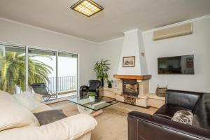 a living room with a couch and a fireplace at Palmeira`s Village in São Gonçalo