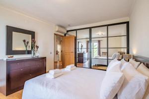 a large bedroom with a white bed and a large window at Palmeira`s Village in São Gonçalo