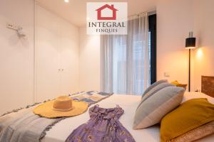 a bed with a hat and a dress on it at Apartament Bella Terra in Palamós
