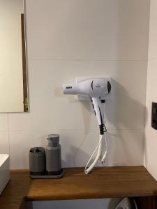 un secador de pelo está colgado en la pared en Casa das Bananeiras 01 quarto, en Bento Gonçalves 10 fotos más