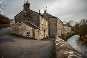 an old stone building next to a river at Riverside Walk in Airton