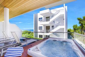 a hot tub on the balcony of a house at Tranquility Beach Anguilla Resort in Meads Bay