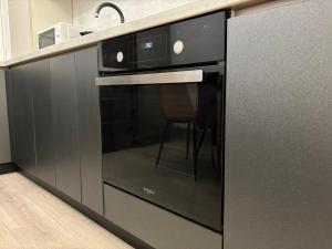 a kitchen with a black oven with a chair in it at Dream - Hotel Experience with ExtraSpace, QuietArea, Balcony, FreeParking in Bistriţa