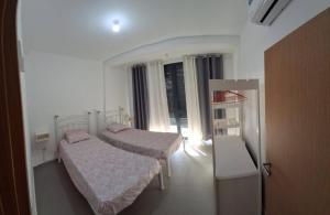 Un dormitorio pequeño con dos camas y una ventana. en Casa Maré & Museu - Porta Nº 18, en Mindelo 15 fotos más