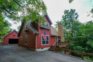 a red house with a flag on it at 3BR with mtn view and hot tub in Wears Valley! in Sevierville