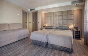 a bedroom with a large bed and a large window at Hotel Suizo in Barcelona