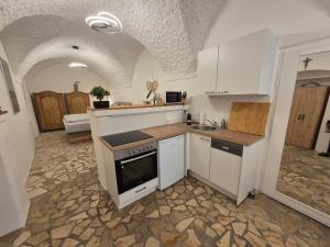 Una cocina con gabinetes blancos y un horno de estufa. en Charmantes Brauerei-Altstadtgewölbe, en Laufen 16 fotos más
