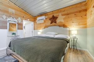 a bedroom with a bed in a room with wooden walls at Waynesville Studio with Fire Pit and Mountain Views! in Waynesville