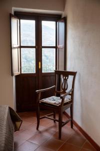 a wooden chair sitting in front of a window at Dimora del Borgo Affittacamere in Sangineto +30 photos
