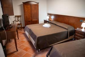 a bedroom with a bed and a desk and a television at Dimora del Borgo Affittacamere in Sangineto
