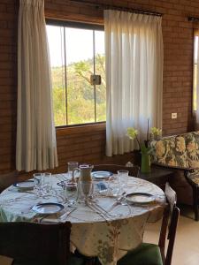 ein Tisch mit Tellern und Gläsern darauf in der Unterkunft Casa ecológica, cheia de conforto, em reserva agroecológica in Espirito Santo Do Pinhal