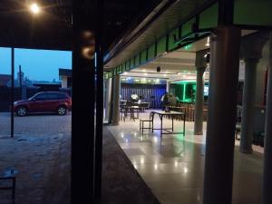 a building with a car parked in a parking lot at MARACANA Taverna Ltd in Kigali