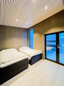 two beds in a room with a window at Modern One-Bedroom Apartment in Henningsvær