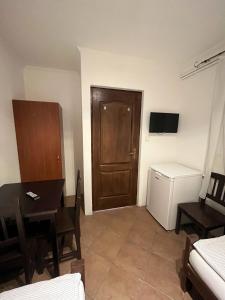 a living room with a table and a room with a door at Vámház Vendégház in Pápa