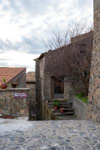 an old stone building with a sign on it at Dimora del Borgo Affittacamere in Sangineto