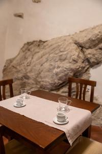 a wooden table with two cups and glasses on it at Dimora del Borgo Affittacamere in Sangineto