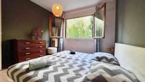 a bedroom with a bed and a dresser and a window at Casamea - Spacieux T3 famille, Vue mer, Parking in Ajaccio