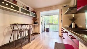 a kitchen with a counter and some stools in it at Casamea - Spacieux T3 famille, Vue mer, Parking in Ajaccio