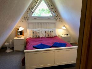a bedroom with a bed with purple sheets and a window at Chalet 67 in Kingsdown +31 photos