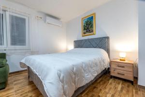 a bedroom with a large white bed and a chair at Apartment Marta - free parking! in Split