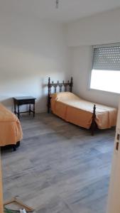 a bedroom with two beds and a table in it at Casa en Miramar Alquiler temporario in Miramar