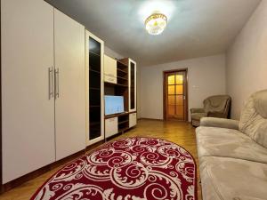 un soggiorno con divano e tappeto rosso di ApartPoltava Затишна 3-кімнатна квартира в центрі міста, КАШТАНОВА АЛЕЯ, звітна документація, ЧЕК a Poltava Altre 13 foto