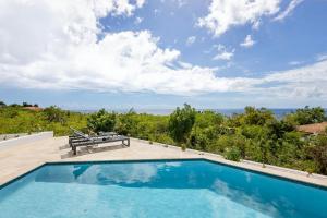 une piscine avec un banc sur une terrasse dans l'établissement Coral Estate Rentals, à Willibrordus