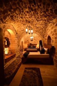 ein großer Raum mit einem Bett in einer Steinwand in der Unterkunft Sultan Konağı Hotel - Heritage Stay in Mardin