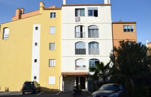 een geel gebouw met auto's ervoor geparkeerd bij Appartement T2 Cap d'Agde in Cap d'Agde