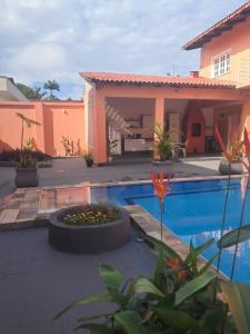 a villa with a swimming pool and a house at Casa Rosa Suítes 5 min de caminhada da PRAIA DA PONTA NGRA in Manaus