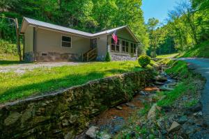 a house with a stone wall next to a road at Newly renovated 2 BR in convenient location! in Sevierville