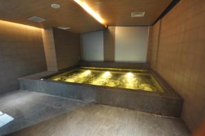 a bathroom with a tub filled with gold water at GTV Hotel in Cikarang