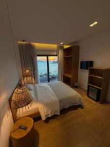 a bedroom with a bed with a view of the ocean at Kanes Boutique Hotel in Sarandë