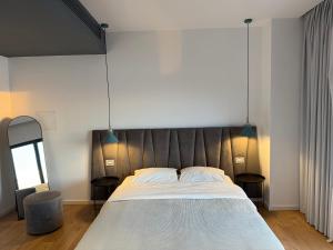 a bedroom with a large bed and two tables at Kanes Bohemian Boutique Hotel in Sarandë
