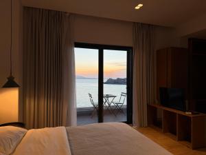 a bedroom with a bed and a view of the ocean at Kanes Boutique Hotel in Sarandë