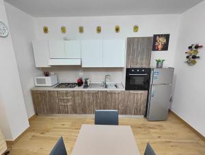 a kitchen with white cabinets and a refrigerator at Casa Etrusca in Fabrica di Roma