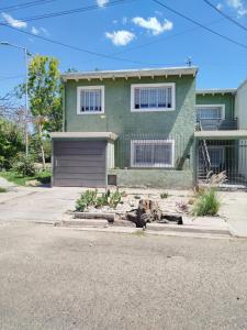 ein grünes Haus mit Garage auf einer Straße in der Unterkunft Yoyiland in Guaymallen