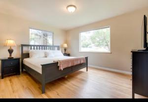 ein Schlafzimmer mit einem großen Bett und zwei Fenstern in der Unterkunft Cherry Creek Colorado in Denver