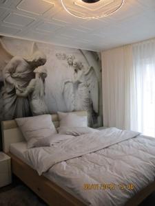 a large bed with a painting on the wall at Schneider House in Ramstein-Miesenbach