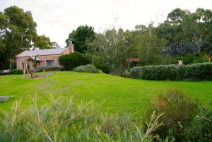 a house in a yard with a green lawn at Pear Tree Hollow in Bald Hills
