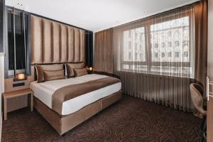 a bedroom with a bed and a large window at Hotel Unique Majestic in Dortmund +10 photos