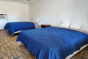 two beds in a room with blue comforter at Crown Inn by OYO Orangeburg Hwy 301 in Orangeburg